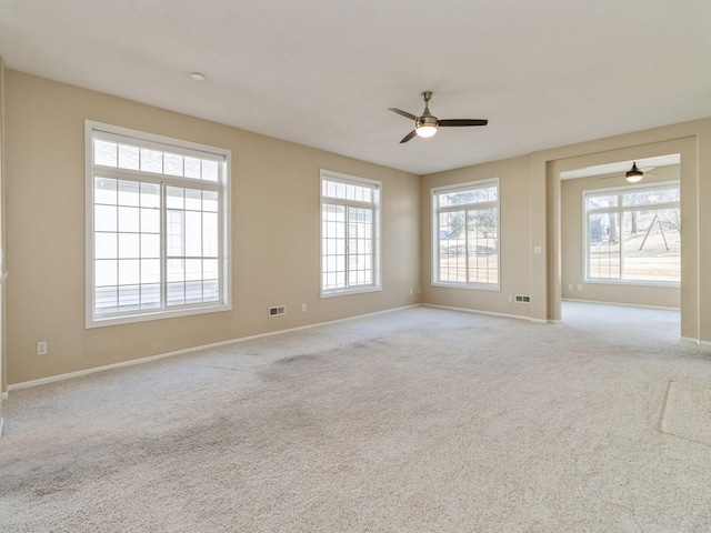 empty room featuring visible vents, baseboards, and carpet