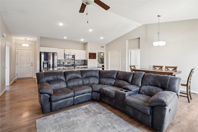 living area with baseboards, recessed lighting, ceiling fan, vaulted ceiling, and light wood-style floors