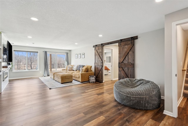 living area with baseboards, stairway, a barn door, recessed lighting, and wood finished floors