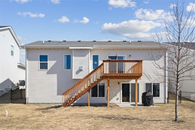 rear view of property with a deck, stairway, a yard, and a fenced backyard