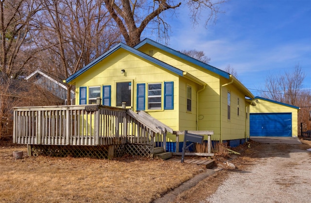 bungalow with a deck and an outbuilding