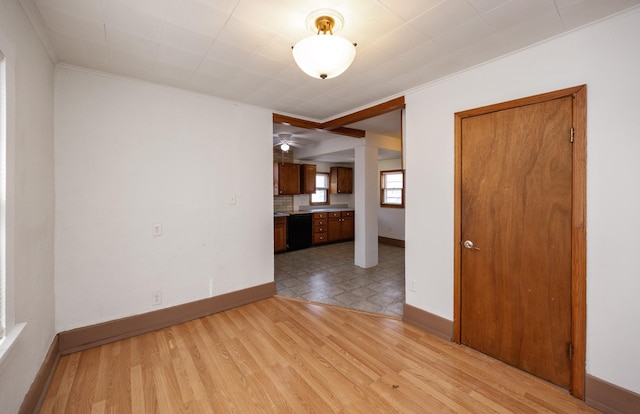 spare room featuring light wood-type flooring, baseboards, and ornamental molding