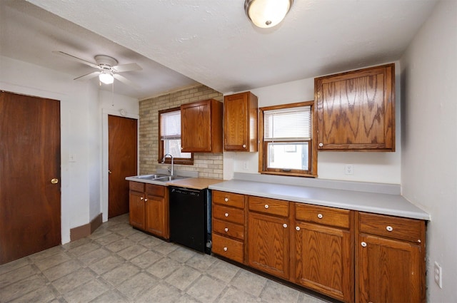 kitchen featuring black dishwasher, light floors, brown cabinets, and a sink