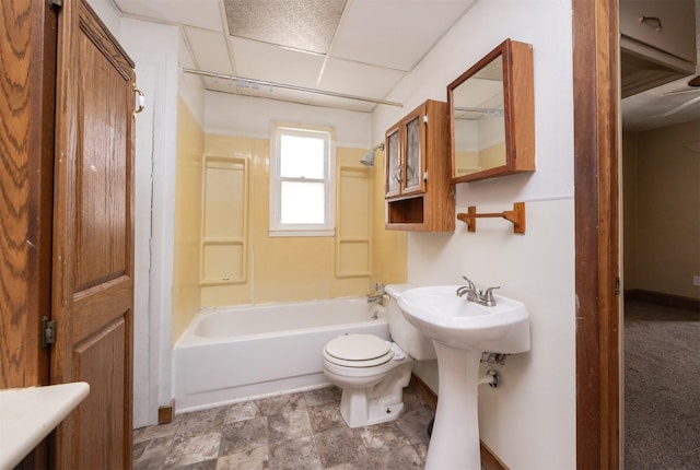 full bathroom featuring a drop ceiling, toilet, and  shower combination