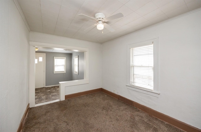 carpeted spare room featuring crown molding, baseboards, and ceiling fan