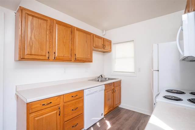 kitchen with white appliances, light countertops, dark wood-type flooring, and a sink