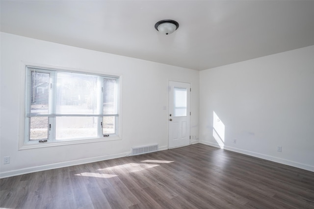 interior space with visible vents, baseboards, and dark wood-style flooring