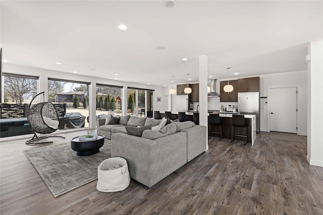 living area featuring recessed lighting, baseboards, and dark wood-style flooring