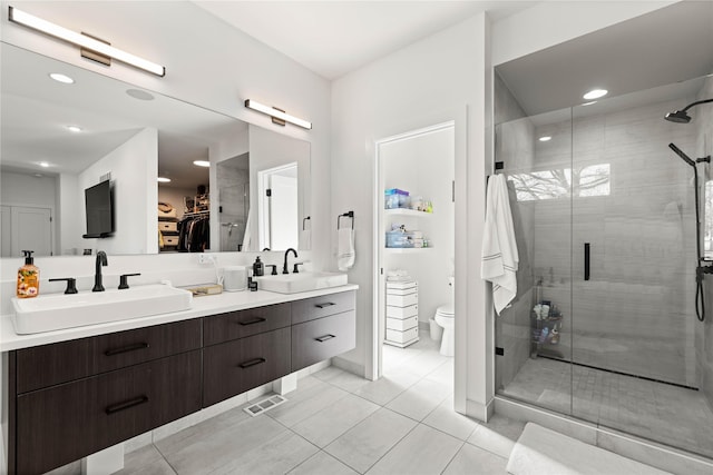 full bath with double vanity, a shower stall, and a sink