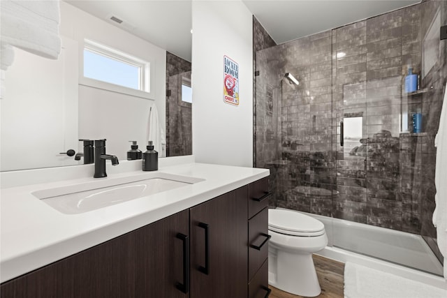 full bathroom featuring visible vents, toilet, wood finished floors, and a shower stall