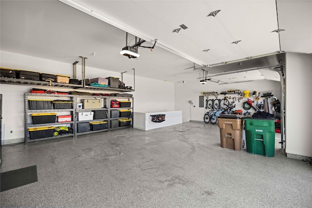 garage with electric panel, baseboards, and a garage door opener