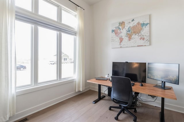 office area featuring light wood-type flooring and baseboards