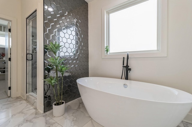 bathroom featuring a stall shower, plenty of natural light, marble finish floor, and a freestanding bath