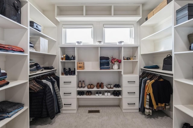 walk in closet featuring visible vents and light colored carpet