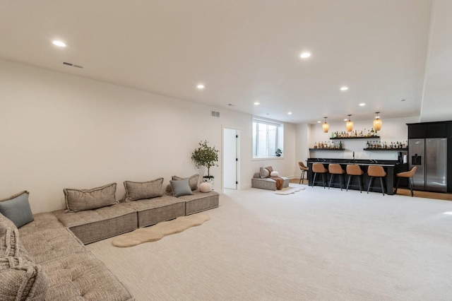 living room with a bar, recessed lighting, light colored carpet, and visible vents