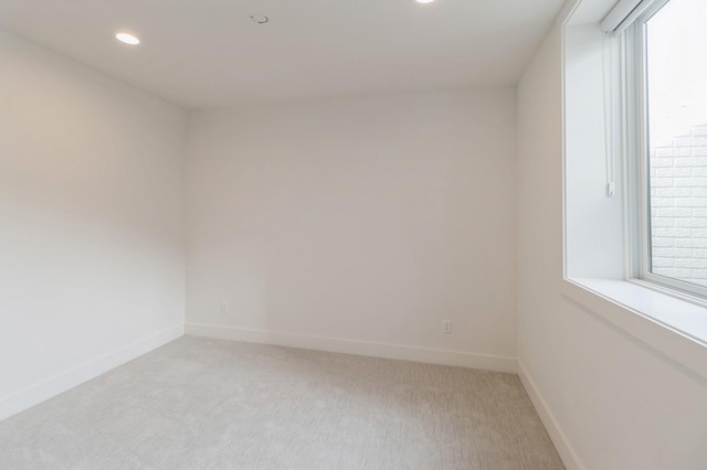 unfurnished room with recessed lighting, baseboards, and light carpet