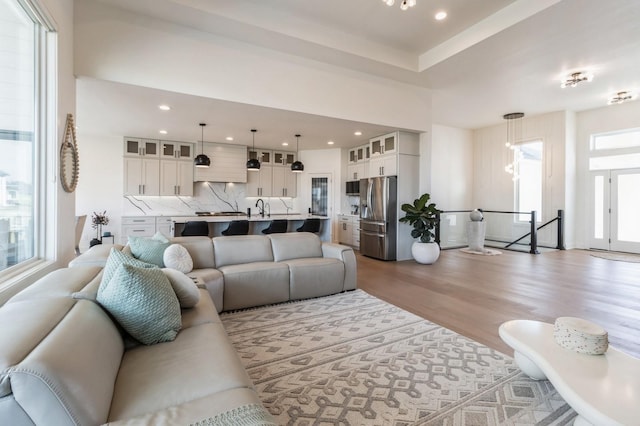 living room featuring recessed lighting, an inviting chandelier, and wood finished floors