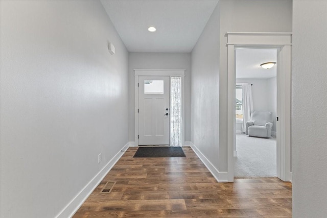 foyer entrance with visible vents, a healthy amount of sunlight, and wood finished floors