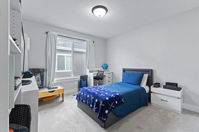 carpeted bedroom featuring a textured ceiling and baseboards