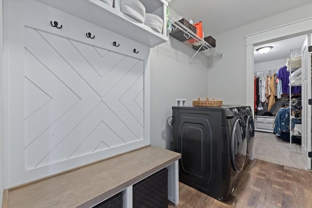 washroom with laundry area, wood finished floors, and washer and clothes dryer