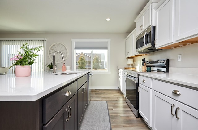 kitchen with appliances with stainless steel finishes, light countertops, and a sink