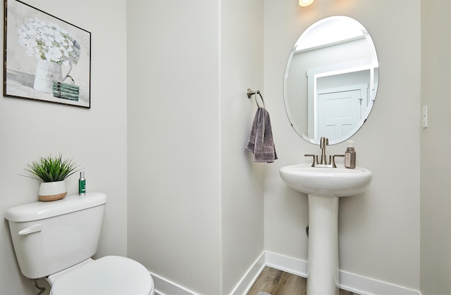 bathroom featuring baseboards, toilet, and wood finished floors