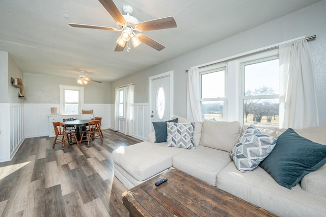 living area featuring plenty of natural light, wood finished floors, and wainscoting