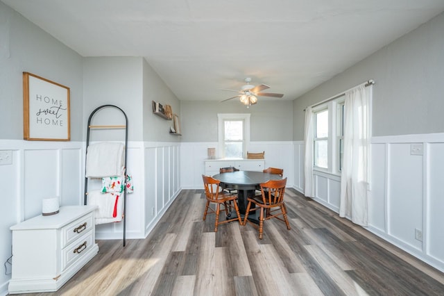 dining area featuring wainscoting, a ceiling fan, and wood finished floors