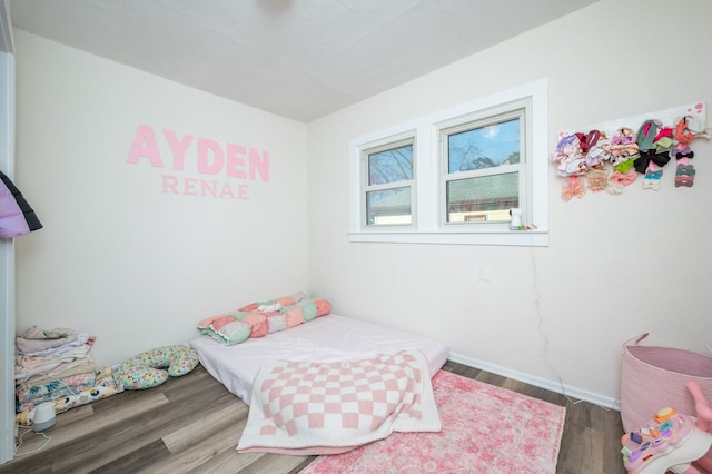 bedroom featuring baseboards and wood finished floors