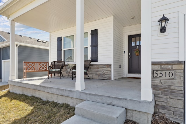 doorway to property with stone siding and covered porch