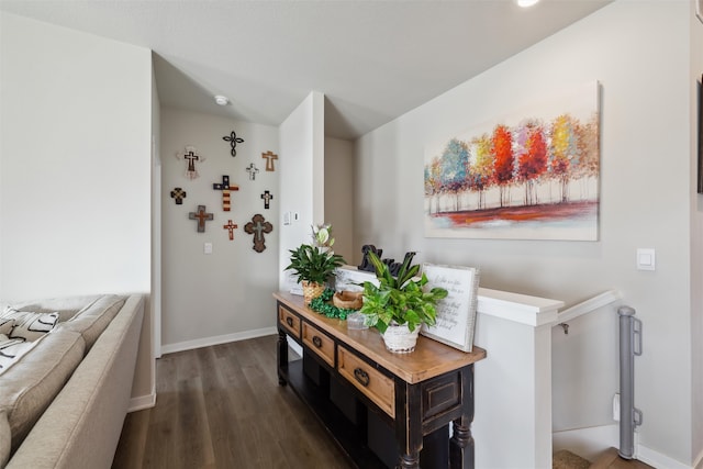 hallway with an upstairs landing, wood finished floors, and baseboards