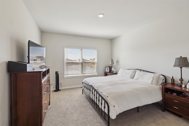 bedroom featuring baseboards and light carpet