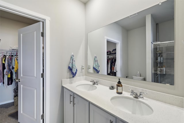 full bath with double vanity, a shower stall, toilet, and a sink