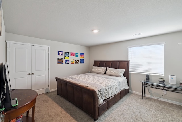 bedroom with light carpet, visible vents, baseboards, and a closet