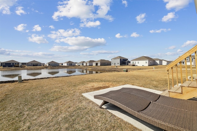 view of yard with a residential view and a water view