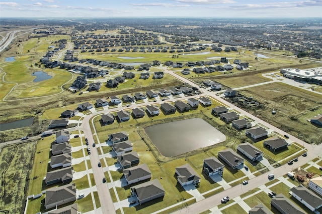 drone / aerial view featuring a residential view, view of golf course, and a water view