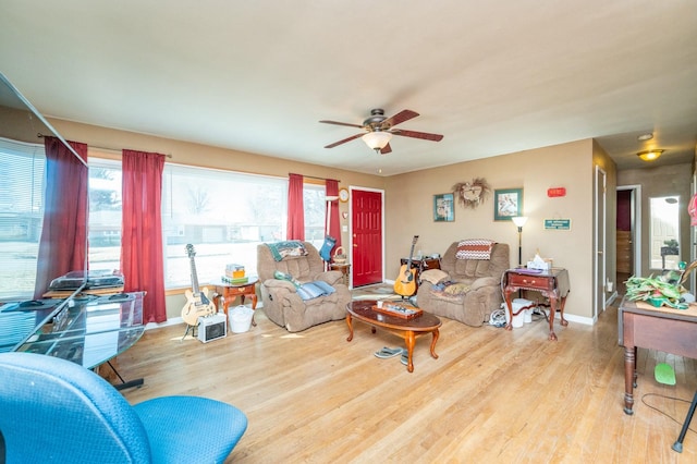 living room with baseboards, a ceiling fan, and wood finished floors