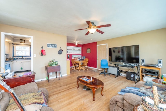 living area with ceiling fan, baseboards, and wood finished floors