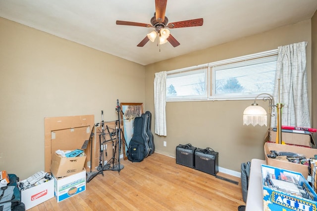 miscellaneous room featuring a ceiling fan, baseboards, and wood finished floors