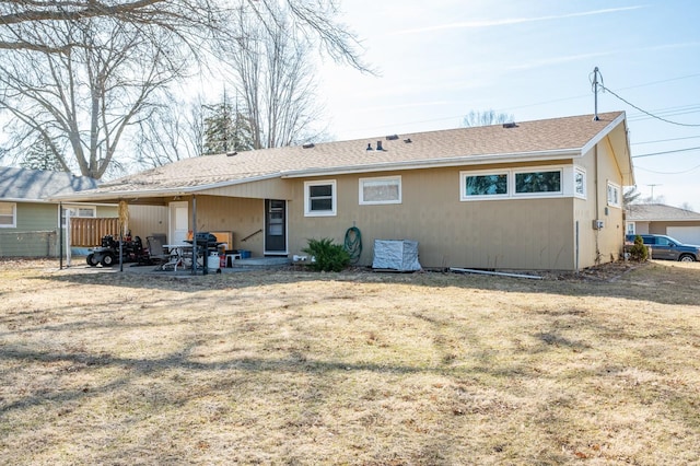 back of property with a patio area, fence, and roof with shingles