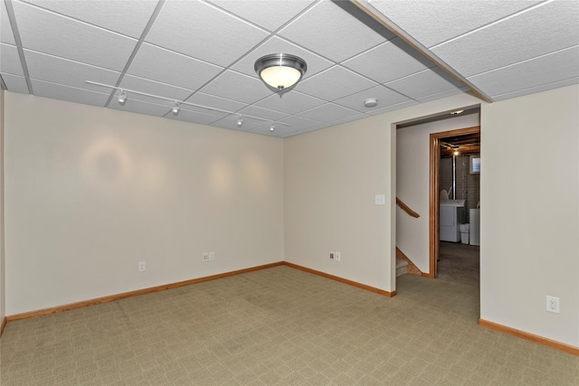 unfurnished room featuring stairway, baseboards, a drop ceiling, rail lighting, and light colored carpet