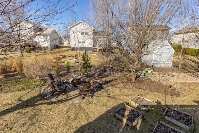 view of yard with stairway, a fire pit, and a garden