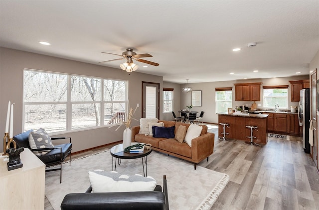 living room featuring recessed lighting, light wood-style floors, baseboards, and ceiling fan