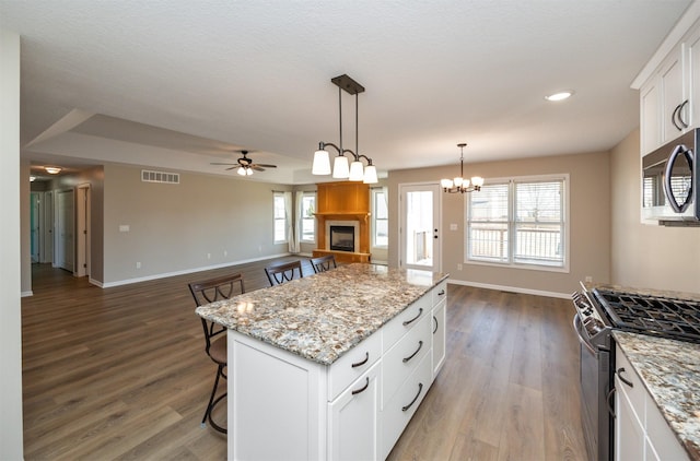 kitchen featuring white cabinetry, wood finished floors, visible vents, and stainless steel appliances