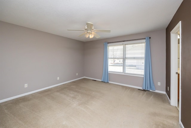 unfurnished room with visible vents, a textured ceiling, baseboards, light colored carpet, and ceiling fan