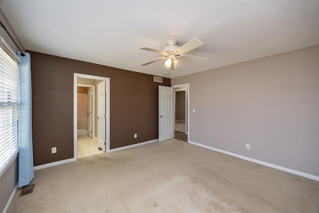 unfurnished bedroom with baseboards, light carpet, and visible vents