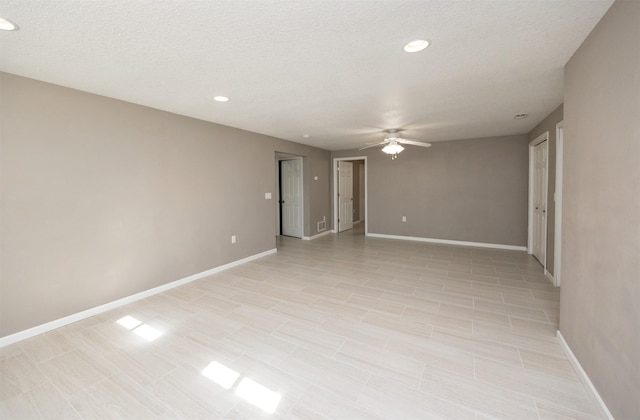 empty room with a textured ceiling, recessed lighting, baseboards, and ceiling fan