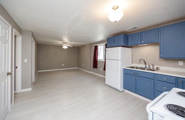 kitchen featuring visible vents, blue cabinetry, light countertops, white appliances, and a sink