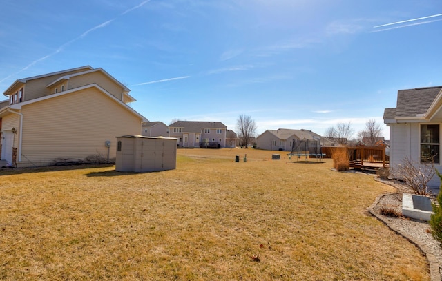 view of yard featuring a trampoline and a residential view