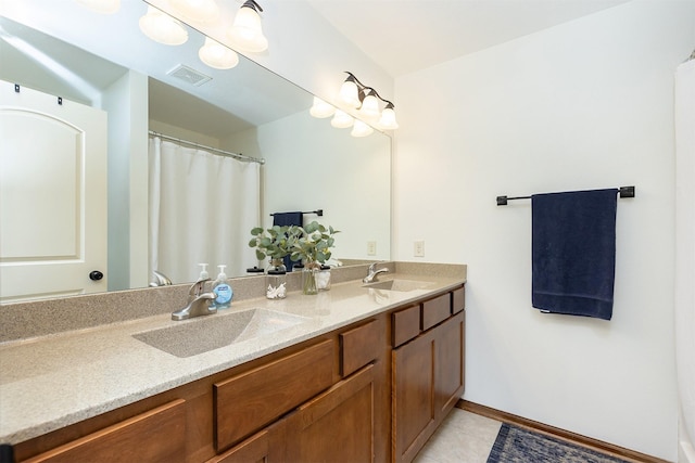 bathroom featuring a sink, visible vents, double vanity, and tile patterned floors